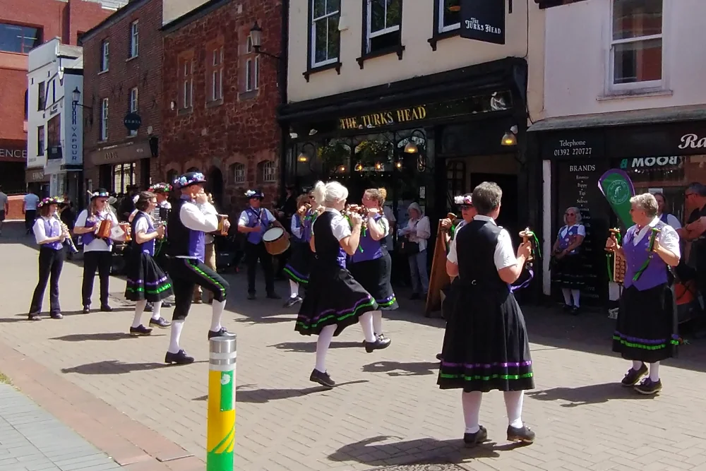 Street audience enjoying traditional dance performances during Exeter event